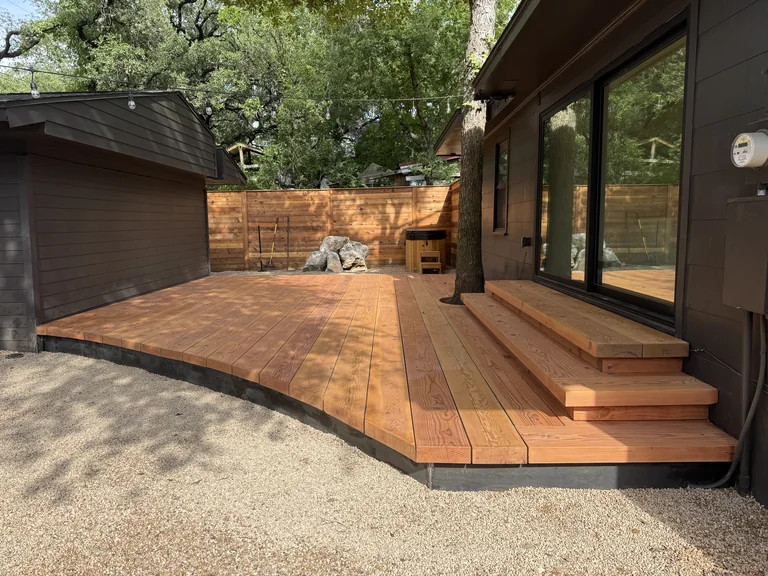 Daylight on substantial wood boards, a curved deck edge and wide steps in a BigDecks courtyard
